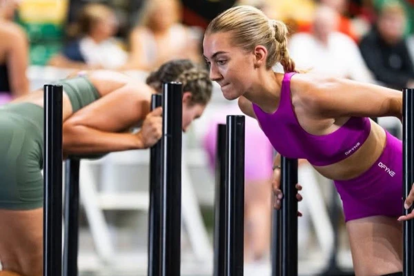 Two women in fitness area are working out with weights